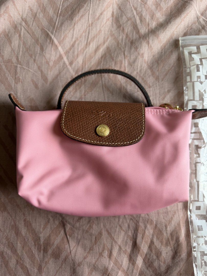 Longchamp Le Pliage Mini Pouch with Strap Pink (Category: Purses & Pouches) located in Manila. Submitted by shopelainevillapando (Listing ID 1459975048, Image 2). Description: - Authentic Pink Longchamp Pouch - Got it for USD120 - Includes original packaging - Detachable strap for versatility - Features leather trim and gold hardware - Tag still attached - Ideal for organizing essentials or as a small crossbody bag.