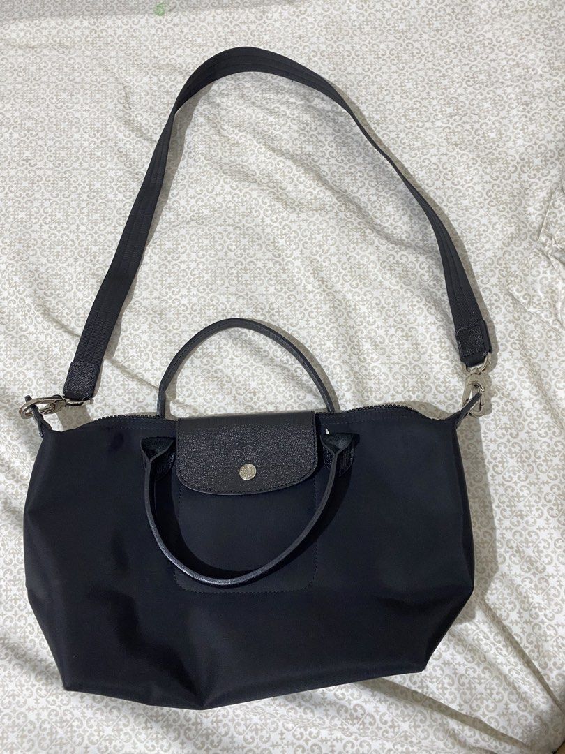 Longchamp Paris Nylon Top Handle Bag (Category: Luxury Bags & Wallets) located in Quezon City. Submitted by irldn_ (Listing ID 1459925743, Image 1). Description: - Longchamp black nylon handbag - Made in France - Versatile: Top handles and detachable shoulder strap - Secure closure: Zipper with leather trim and snap button flap - Interior detail: Small embossed horse logo.