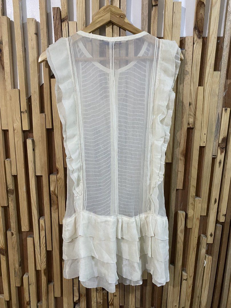 MAJE White Ruffled Sheer Mini Dress (Category: Dresses) located in Angeles City. Submitted by calmrabbit.ae2127 (Listing ID 1459975579, Image 3). Description: - White sheer mini dress by Maje - Features ruffled details on sleeves and hem - Button-up front closure - Made from lightweight and airy fabric - Versatile for layering or wearing solo - Perfect for beach vacations or casual days out.