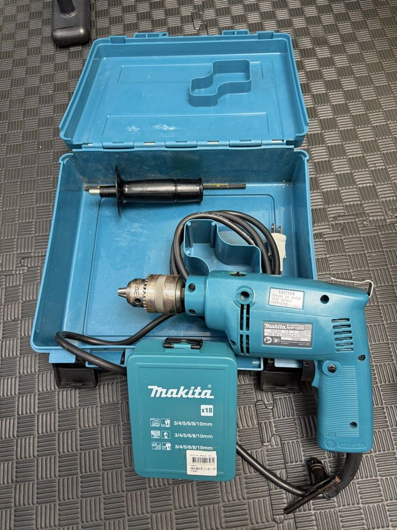 Makita Hammer Drill NHP1300S with Drill Bits and Case (Category: Construction Tools & Equipment) located in Manila. Submitted by mommyzel (Listing ID 1459970568, Image 2). Description: - Makita NHP1300S Hammer Drill - Powerful 430W motor - Variable speed: 0-2700 RPM - Comes with a set of drill bits - Includes original case for storage - Auxiliary handle for better control - Ideal for various drilling applications.