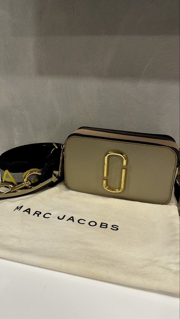Marc Jacobs Snapshot Camera Bag with Strap (Category: Luxury Bags & Wallets) located in Rizal. Submitted by dumbchowdy (Listing ID 1460037394, Image 1). Description: - Authentic Marc Jacobs Camera Bag - Color: Neutral Beige - Iconic Gold Double J Logo on Front - Comes with Black and Yellow Striped Strap - Includes Original Dust Bag - Ideal for Everyday Use.