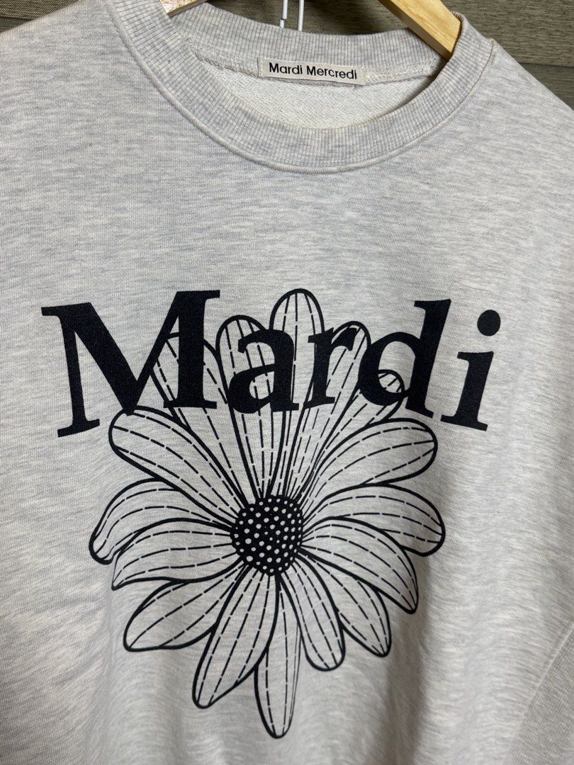 Mardi Mercredi Grey Daisy Sweatshirt (Category: Coats, Jackets and Outerwear) located in Santa Ana. Submitted by thrift.sanctuary (Listing ID 1460082491, Image 3). Description: - Grey sweatshirt from Mardi Mercredi - Features signature daisy graphic on the front - Classic crew neck and long sleeves - Comfortable and casual design - Versatile for pairing with jeans or shorts - Ideal for everyday wear.