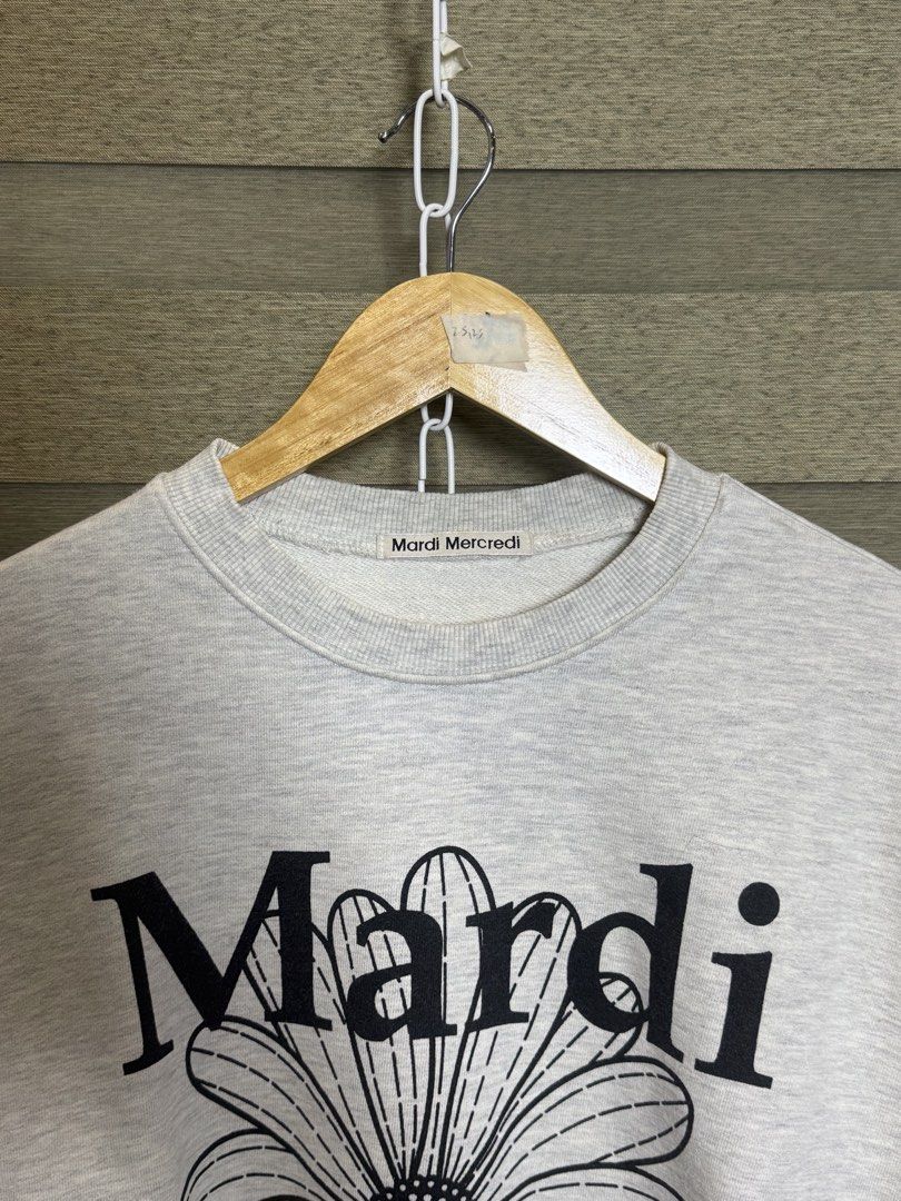 Mardi Mercredi Grey Daisy Sweatshirt (Category: Coats, Jackets and Outerwear) located in Santa Ana. Submitted by thrift.sanctuary (Listing ID 1460082491, Image 2). Description: - Grey sweatshirt from Mardi Mercredi - Features signature daisy graphic on the front - Classic crew neck and long sleeves - Comfortable and casual design - Versatile for pairing with jeans or shorts - Ideal for everyday wear.