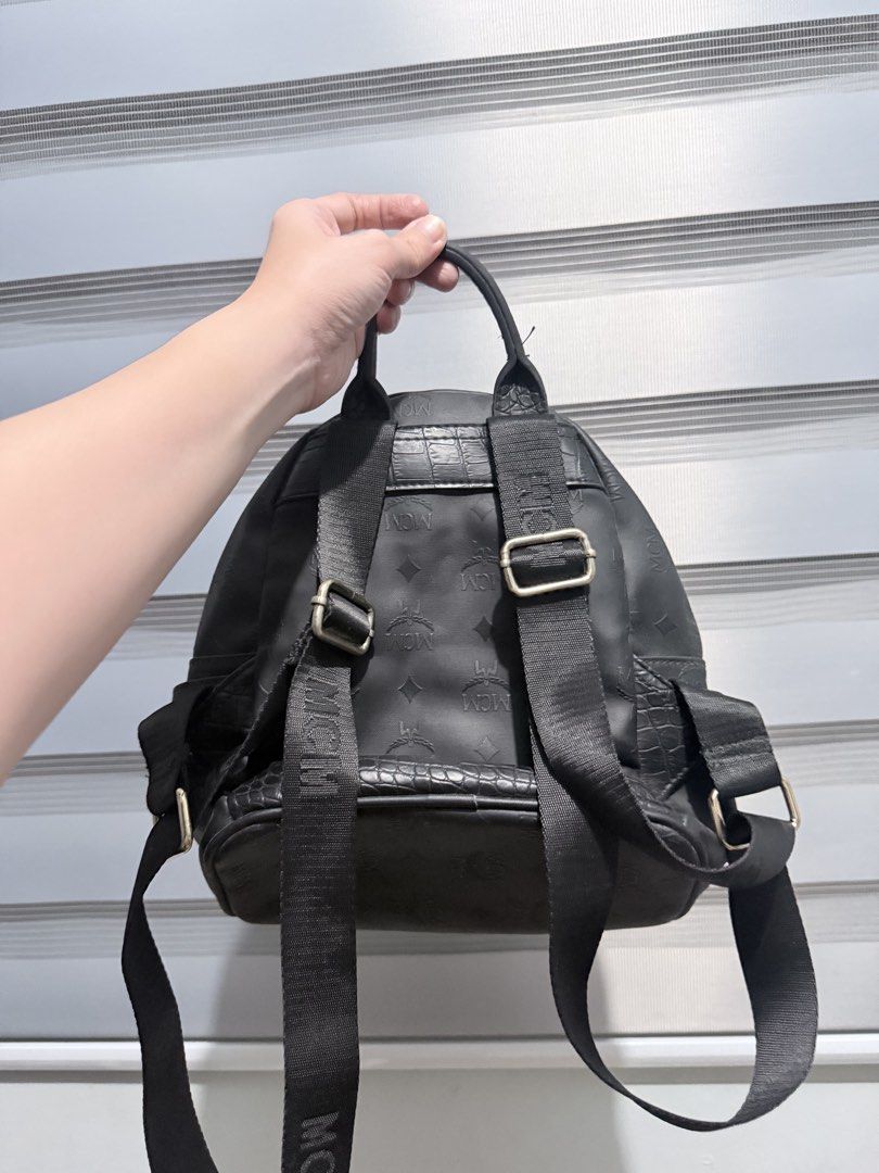 MCM Stark Studded Backpack (Category: Backpacks) located in Manila. Submitted by prelovedbygayle (Listing ID 1460099588, Image 2). Description: Material: Black Visetos monogram coated canvas with leather trim. Exterior Pockets: Front zipper compartment and dual flat side pockets. Hardware: Front panel detailed with a diamond-shaped stud configuration and an MCM branded metal plate. Straps: Adjustable canvas shoulder straps with a leather top hand