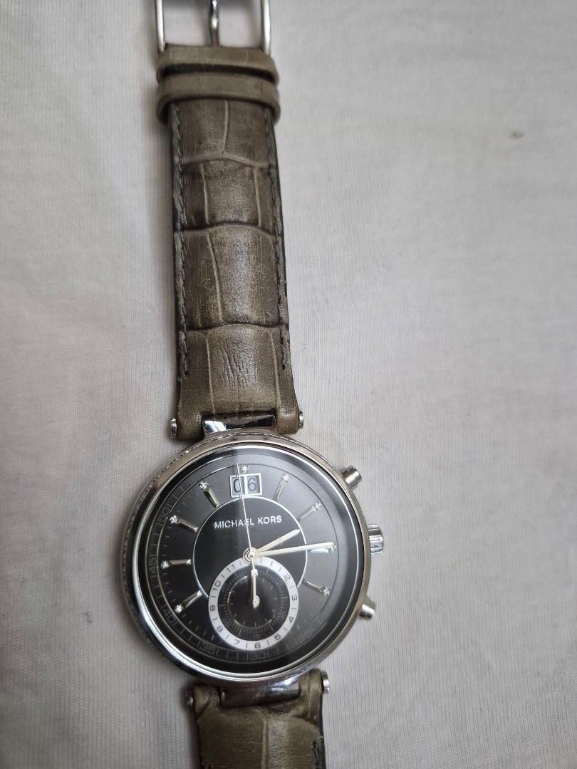 Michael Kors Chronograph Watch Grey Leather Strap (Category: Luxury Watches) located in Manila. Submitted by goldenphoenix_1e67c6 (Listing ID 1459968689, Image 1). Description: - Brand: Michael Kors - Strap: Grey leather with textured, crocodile-like finish - Dial: Dark grey chronograph with date function - Case: Silver-tone - Closure: Buckle MK Sawyer.