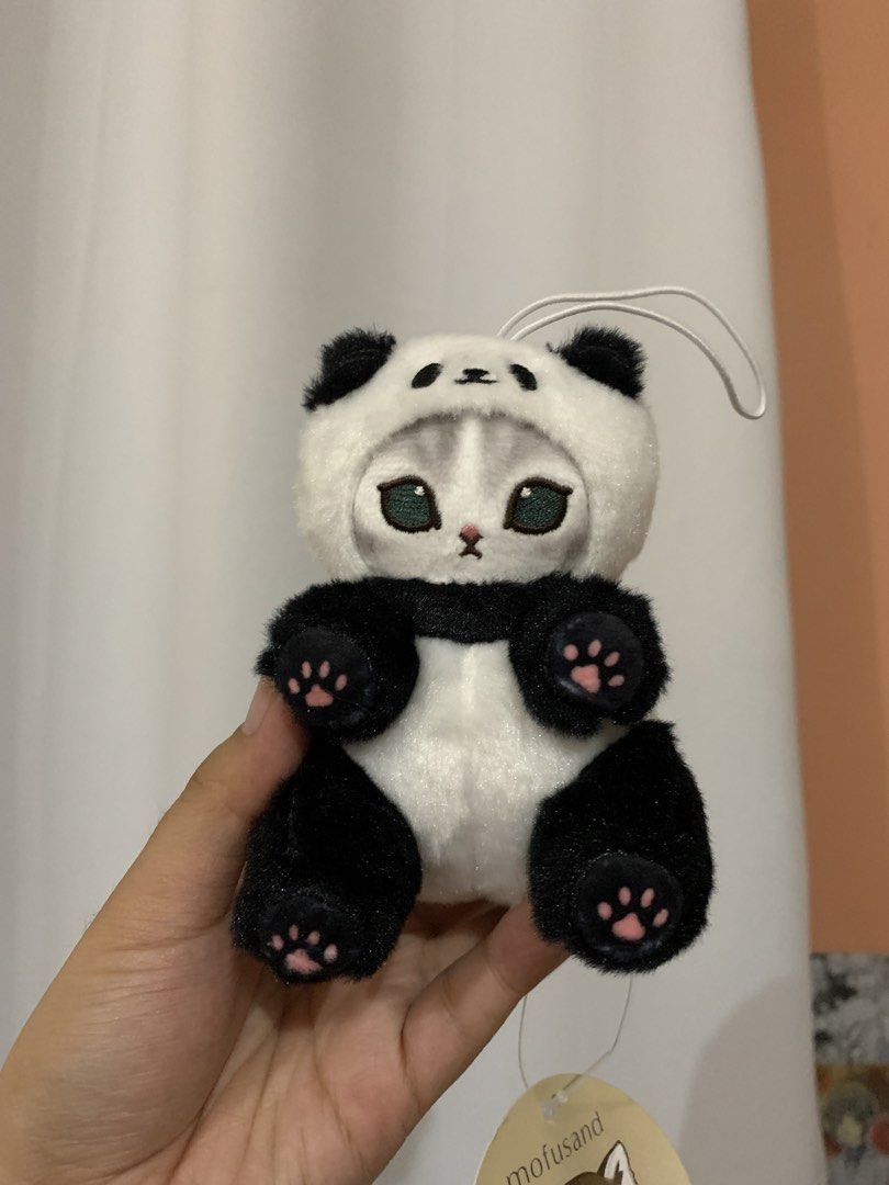 Mofusand Panda Cat Plush Keychain (Category: Plushies & Soft Toys) located in Tagaytay City. Submitted by jujujewel (Listing ID 1459903446, Image 1). Description: - Adorable Mofusand plush toy - Features a cat dressed as a panda - Includes a loop for easy attachment to bags or keys - Brand new with original tag still attached - Ideal gift for Mofusand enthusiasts and cat lovers - Soft and cuddly material.