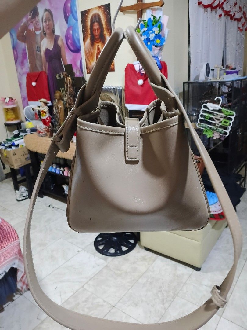 Mossdoom Taupe Bucket Bag with Shoulder Strap (Category: Shoulder Bags) located in Cavite. Submitted by ms.de.clutter (Listing ID 1460041757, Image 2). Description: - Stylish taupe bucket bag - Versatile: top handle and detachable shoulder strap - Elegant gold hardware details - Secure interior drawstring pouch - Ideal for everyday use and carrying essentials.