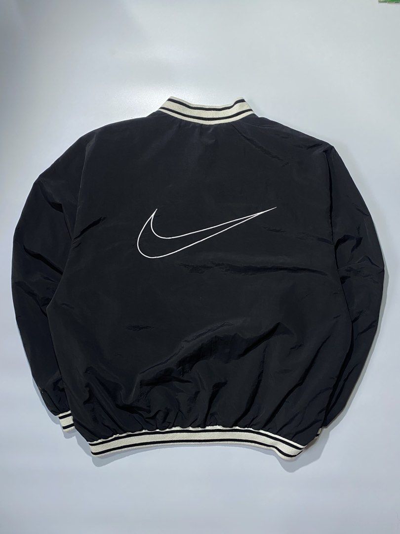 Nike Black Pullover V-Neck Jacket with Swoosh Logo (Category: Coats, Jackets and Outerwear) located in Caloocan City. Submitted by retrowear.gallery (Listing ID 1460026838, Image 3). Description: - Black Nike pullover jacket - V-neck collar with white stripes - White Nike swoosh on chest - Large white swoosh graphic on back - Elasticated cuffs and hem - Ideal for casual wear or sports.