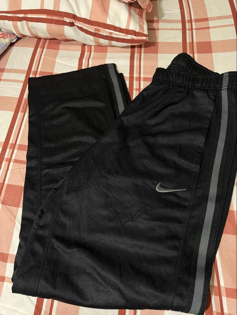 Nike Drifit Black Track Pants with Grey Stripes (Category: Joggers) located in Pasay City. Submitted by Oboyyy (Listing ID 1459793244, Image 1). Description: - Black Nike track pants - Iconic embroidered Nike swoosh logo on left leg - Two grey stripes down the sides of each leg - Comfortable elastic waistband - Ideal for sports or casual wear.