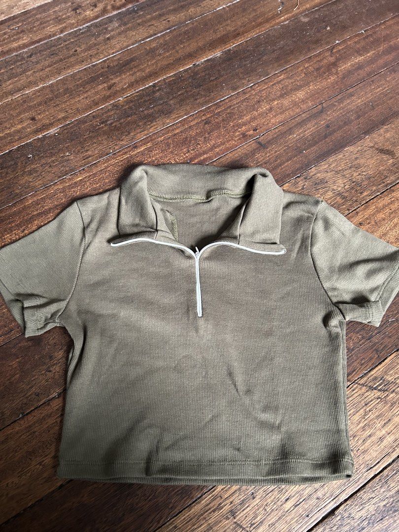 Olive Green Ribbed Zip Neck Cropped Top (Category: Blouses) located in Manila. Submitted by swift_cloudio (Listing ID 1459935673, Image 1). Description: - Olive green cropped top - Ribbed material for texture - Features a stylish zip neck detail - Short sleeves for a breezy feel - Best fits size Small to Medium - Ideal for everyday casual wear.