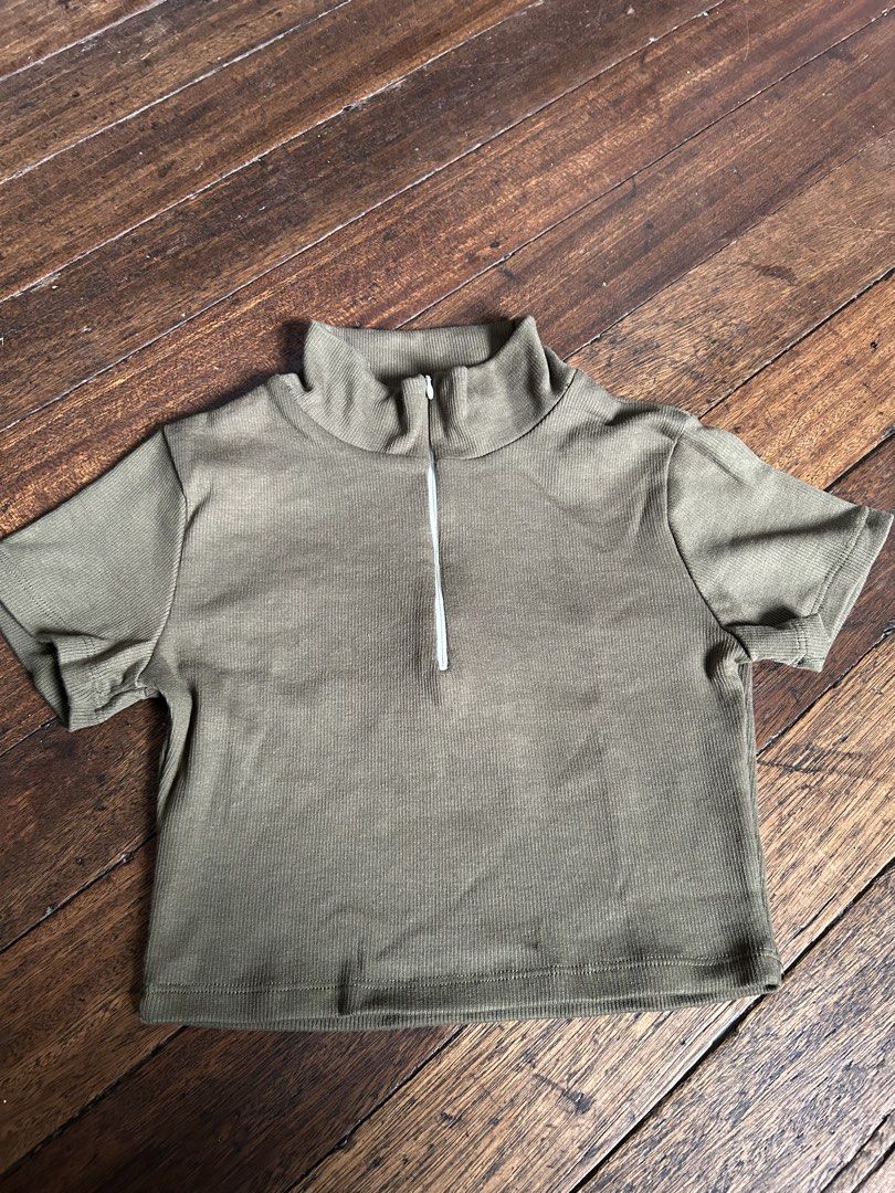 Olive Green Ribbed Zip Neck Cropped Top (Category: Blouses) located in Manila. Submitted by swift_cloudio (Listing ID 1459935673, Image 2). Description: - Olive green cropped top - Ribbed material for texture - Features a stylish zip neck detail - Short sleeves for a breezy feel - Best fits size Small to Medium - Ideal for everyday casual wear.