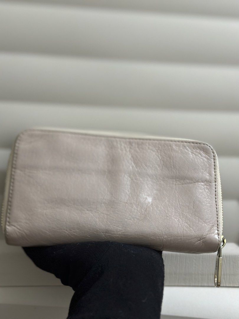 Original Chloe Leather Bow Zip Around Wallet (Category: Wallets & Card holders) located in Naga. Submitted by bag.net (Listing ID 1459967172, Image 2). Description: - Authentic Chloe wallet(sourced from Japan 🇯🇵)Guaranteed original 💯 moneyback guaranteed if proven fake - Color: Light beige/pinkish leather - Signature bow detail on front pocket - Zip-around closure - Interior: Multiple card slots and compartments - Hardware: Gold-tone - Conditi
