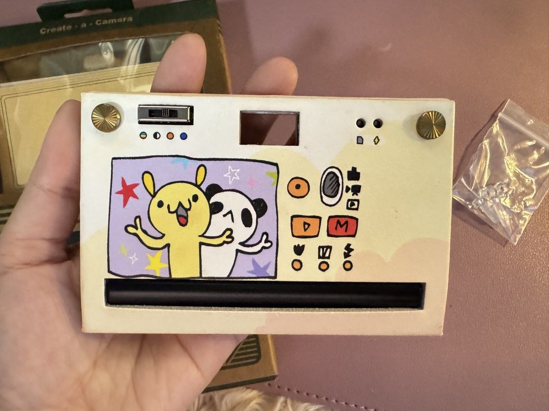 Papershoot Camera with Custom Art Design (Category: Cameras) located in Del Monte. Submitted by hipejoana (Listing ID 1459912902, Image 3). Description: Paper Shoot Camera + 2 Lenses 📸✨ Selling my pre-loved Paper Shoot Digital Camera with: • Macro Lens 25–40mm • 0.68× Wide Angle Lens • USB cable • Strap/accessories • Original box/packaging Cute custom red design ❤️ Perfect for travel, OOTD, family photos & aesthetic/film-style shots! 📌 Pre-love