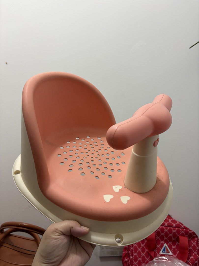 Pink Baby Bath Seat with Support (Category: Bathtub & Bath Accessories) located in Quezon City. Submitted by decluttersbymhira (Listing ID 1459972807, Image 1). Description: - Adorable pink and cream baby bath seat - Features a secure front support for baby's safety - Perforated seat design allows for easy water drainage - Cute heart details add a touch of charm - Makes bath time safe, comfortable, and enjoyable.