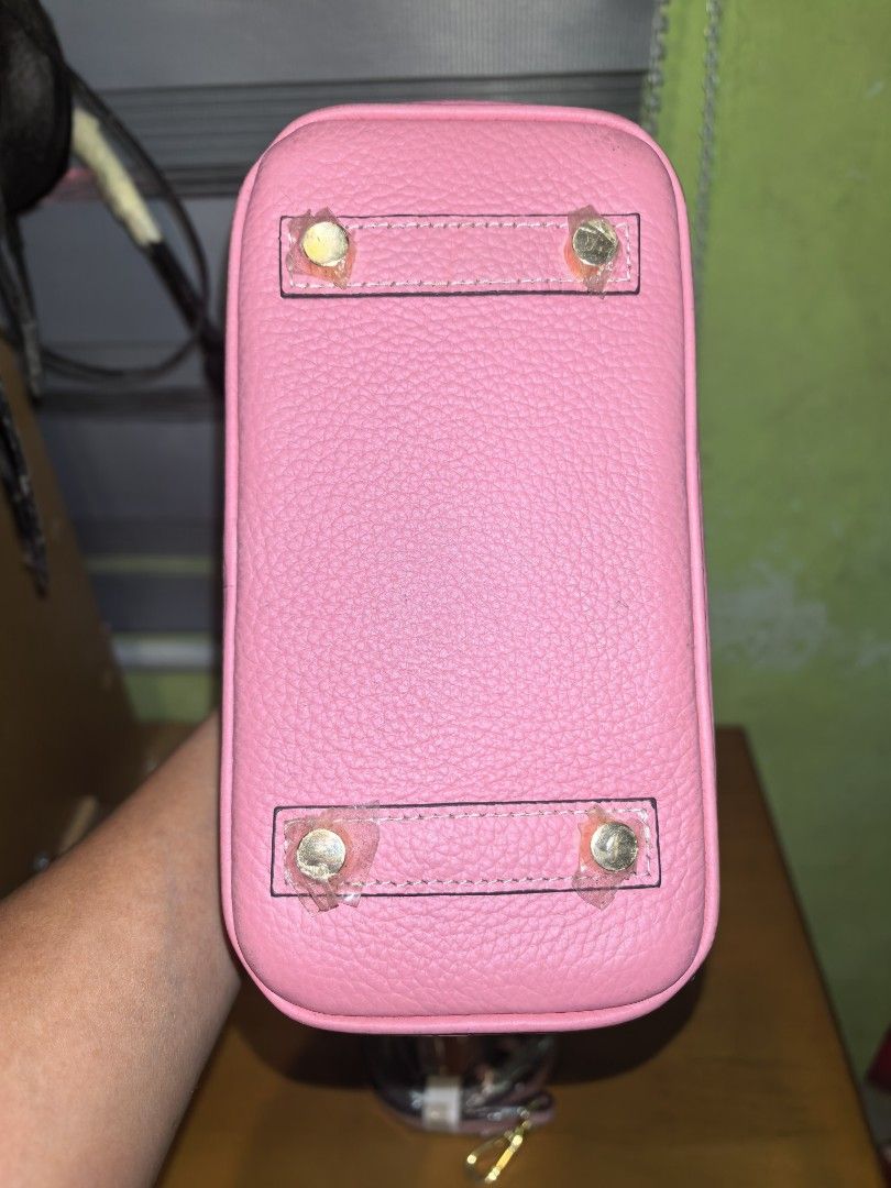 Pink Leather Top Handle Bag with Shoulder Strap (Category: Shoulder Bags) located in Manila. Submitted by mysticfox.9b1678 (Listing ID 1459961687, Image 2). Description: - Adorable pink leather bag - Includes a detachable shoulder strap - Features elegant gold hardware details - Protective stickers still on bottom studs - Versatile for everyday or special events - Spacious interior for your essentials.