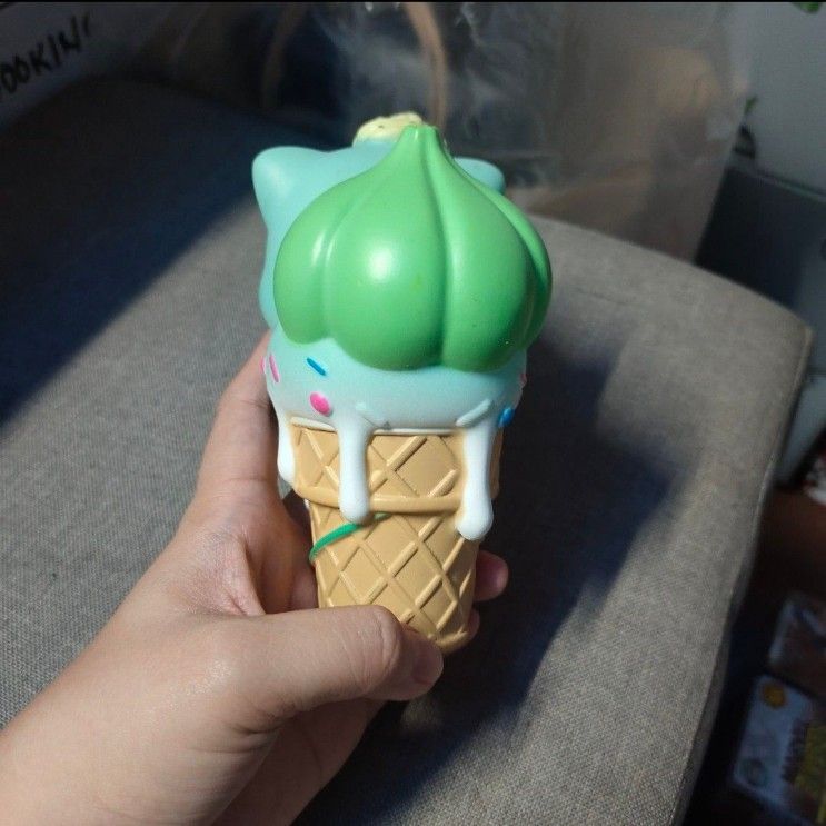Pokemon Bulbasaur Ice Cream Figurine Toy (Category: Designer & Blind Box Toys) located in Quezon City. Submitted by dncpreloved (Listing ID 1459968995, Image 2). Description: - Adorable Bulbasaur shaped like an ice cream cone. - Features a light blue body with a green ice cream top. - Decorated with sprinkles on the ice cream and Bulbasaur's head. - Makes a charming desk decoration..