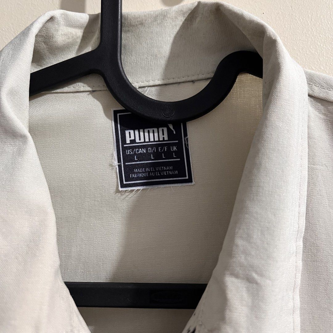 Puma Jacket L Beige Zip Up Utility Style (Category: Coats, Jackets and Outerwear) located in Makati City. Submitted by mikatamayo (Listing ID 1459939146, Image 2). Description: - Beige Puma Jacket - Size: Large (L) - Zip-up front closure - Multiple pockets for storage - Features a zippered chest pocket - Small, distinctive orange circular logo on the right chest - Made in Vietnam - Ideal for casual outfits or as a layering piece.