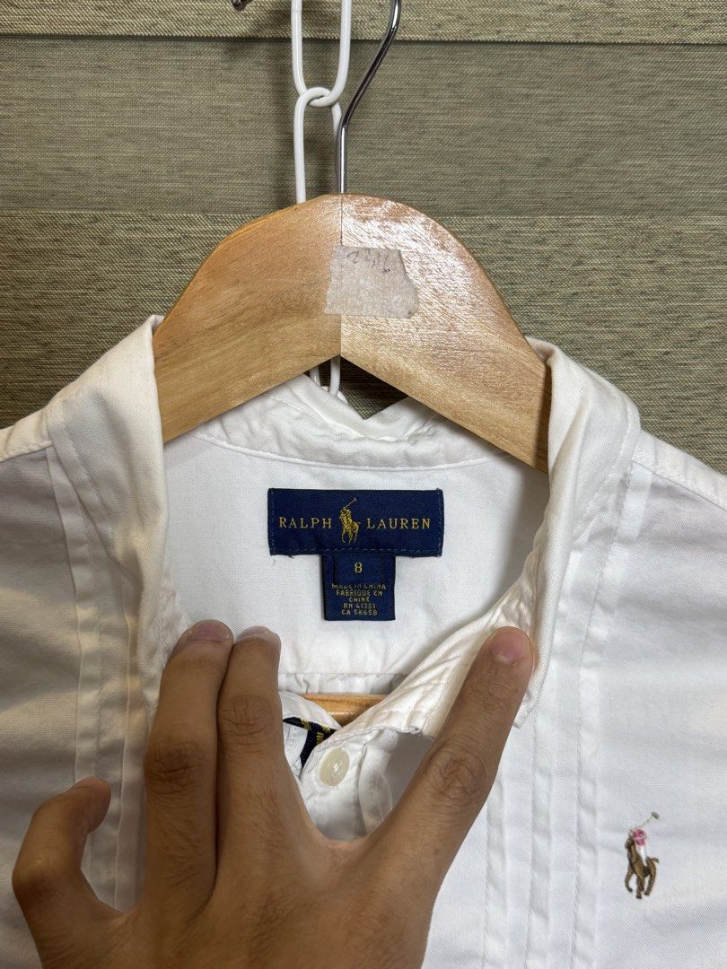 Ralph Lauren White Button Down Shirt Size 8 (Category: Tshirts & Polo Shirts ) located in Santa Ana. Submitted by thrift.sanctuary (Listing ID 1460082450, Image 3). Description: - White Ralph Lauren button down shirt - Size 8 - Ruffled front detail - Classic pony logo - Long sleeves with button cuffs - Versatile for dressing up or down.
