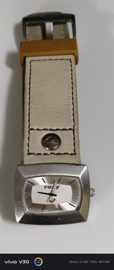 Roxy Watch with Leather Strap (Category: Women's Watches) located in Manila. Submitted by roblazo25 (Listing ID 1459971186, Image 1). Description: - Roxy watch - Cream-colored leather strap with signs of wear (marks, creasing) - Rectangular watch face with white dial - Features Roxy logo - Buckle closure - Perfect accessory for everyday wear.