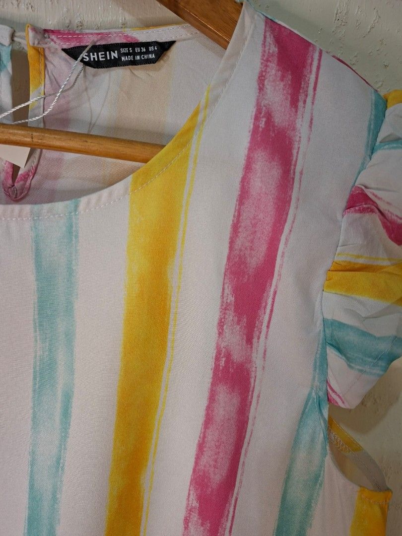 SHEIN MULTICOLOR STRIPED BLOUSE (Category: Activewear) located in Caloocan City. Submitted by pvaliao (Listing ID 1459933288, Image 2). Description: SHEIN multicolor striped blouse featuring a bright, dopamine inspired palette of yellow, pink, turquoise vertical watercolor stripes. It is designed with a classic round neckline, lightweight woven fabric, and playful ruffle flounce cap sleeves, and a small keyhole button closure at the back of the n