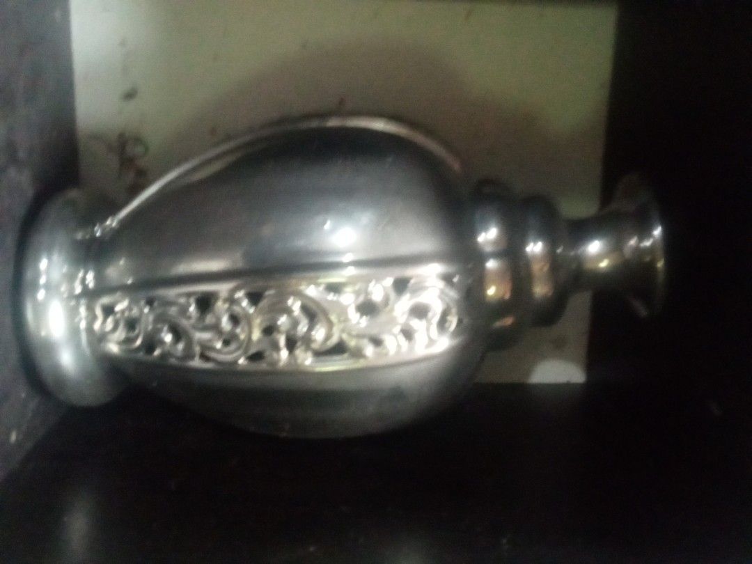 Silver Decorative Vase with Ornate Cutout Design (Category: Vases & Decorative Bowls) located in Paranaque City. Submitted by dimaguilaa94969 (Listing ID 1460054204, Image 1). Description: - Beautiful silver vase - Features an intricate cutout pattern around the middle - Ribbed detail on the neck - Classic urn shape with a flared opening - Ideal for displaying flowers or as a standalone decorative piece - Adds a touch of elegance to any room.