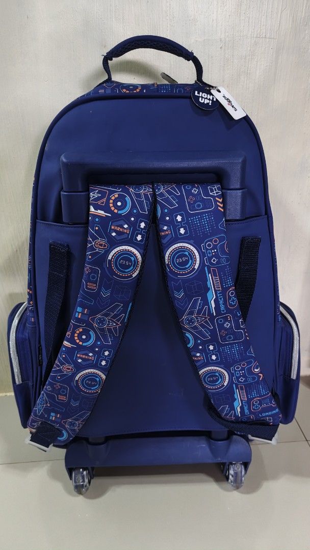 Smiggle Backpack with Light-Up Controller Design (Category: Strollers) located in Valenzuela. Submitted by ataraonlineshop (Listing ID 1459902212, Image 2). Description: - Cool Smiggle backpack for kids - Fun, light-up gaming controller design - Navy blue color - Multiple pockets and compartments - Wheels and pull-up handle for easy transport - Padded straps for comfort - Perfect for school or travel.