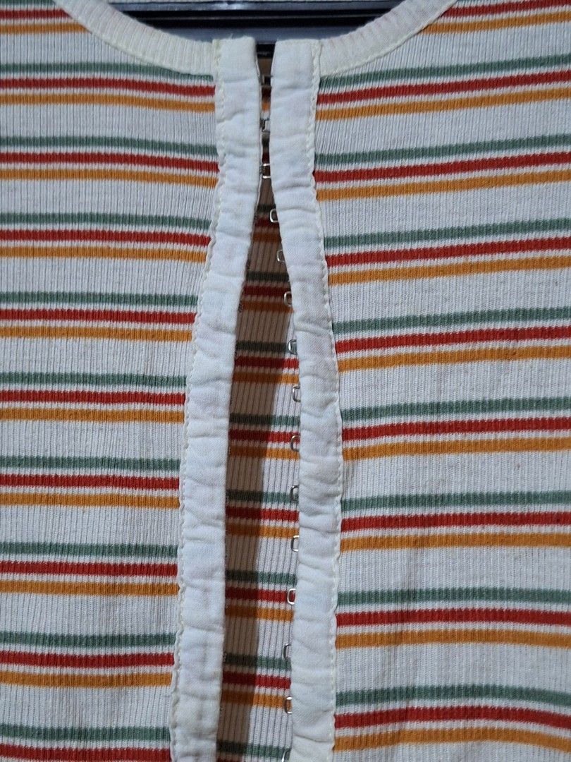 Striped Cropped Top Size S (Category: Others Tops) located in Manila. Submitted by viiiieve (Listing ID 1460084857, Image 2). Description: - Cute cropped top - Features a ribbed texture - Unique front cut-out detail with hook-and-eye closures - Striped pattern in red, orange, green, and white - Perfect for casual wear.