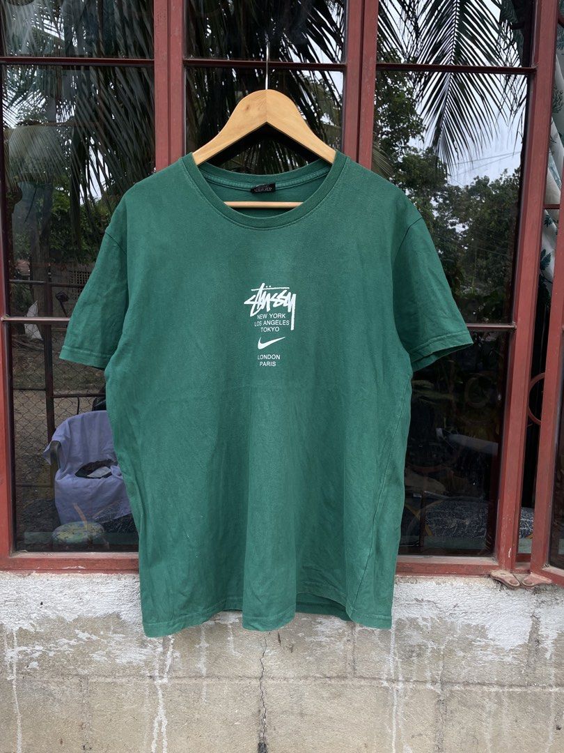 Stussy x nike (Category: Tshirts & Polo Shirts ) located in Quezon. Submitted by thriftedbyandie (Listing ID 1460027199, Image 1). Description: This is a green Nike x Stüssy International T-Shirt featuring the collaborative chest graphic that combines the classic Stüssy script, international city names, and the Nike Swoosh ₱600 plus sf📥📥.