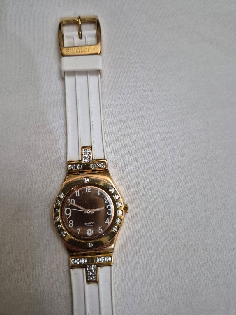 Swatch Watch Gold Tone White Strap Crystal Accents (Category: Women's Watches) located in Manila. Submitted by goldenphoenix_1e67c6 (Listing ID 1459969421, Image 1). Description: - Authentic Swatch watch - Gold-tone case - White strap with gold buckle - Bezel and strap accented with clear crystals - Swiss made quality - Includes original Swatch case.