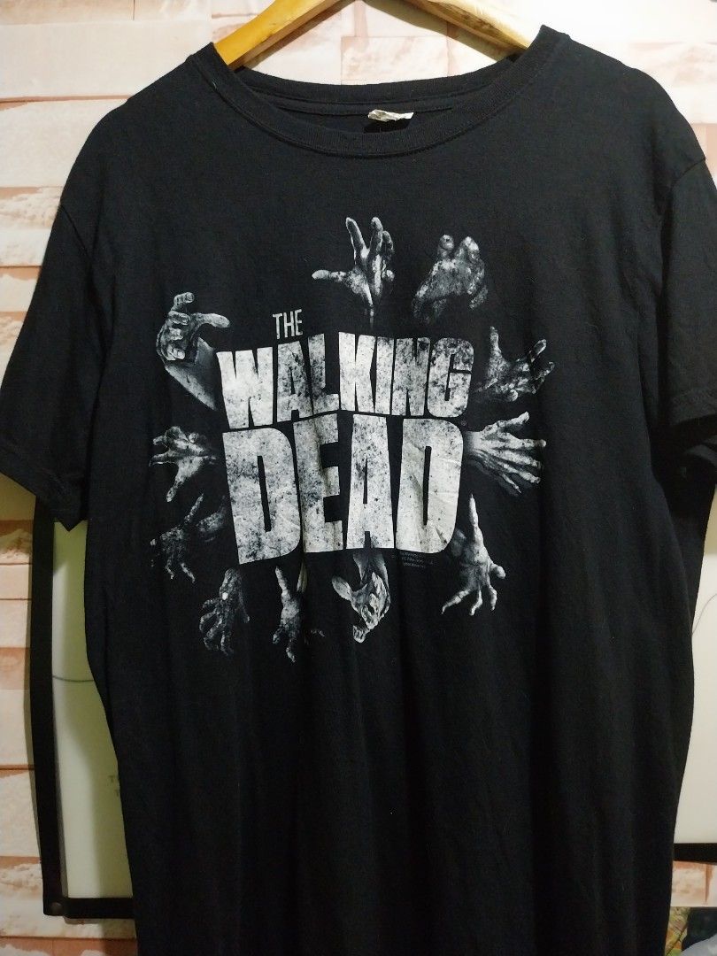 The Walking Dead AMC T-Shirt (Category: Tshirts & Polo Shirts ) located in Taguig. Submitted by lumangdamit (Listing ID 1460059506, Image 1). Description: - Black t-shirt with 'The Walking Dead' graphic - Features zombie hands reaching out design - Made by Keya USA - Perfect for fans of the show - Made from soft ring spun cotton -21x29 dimes.