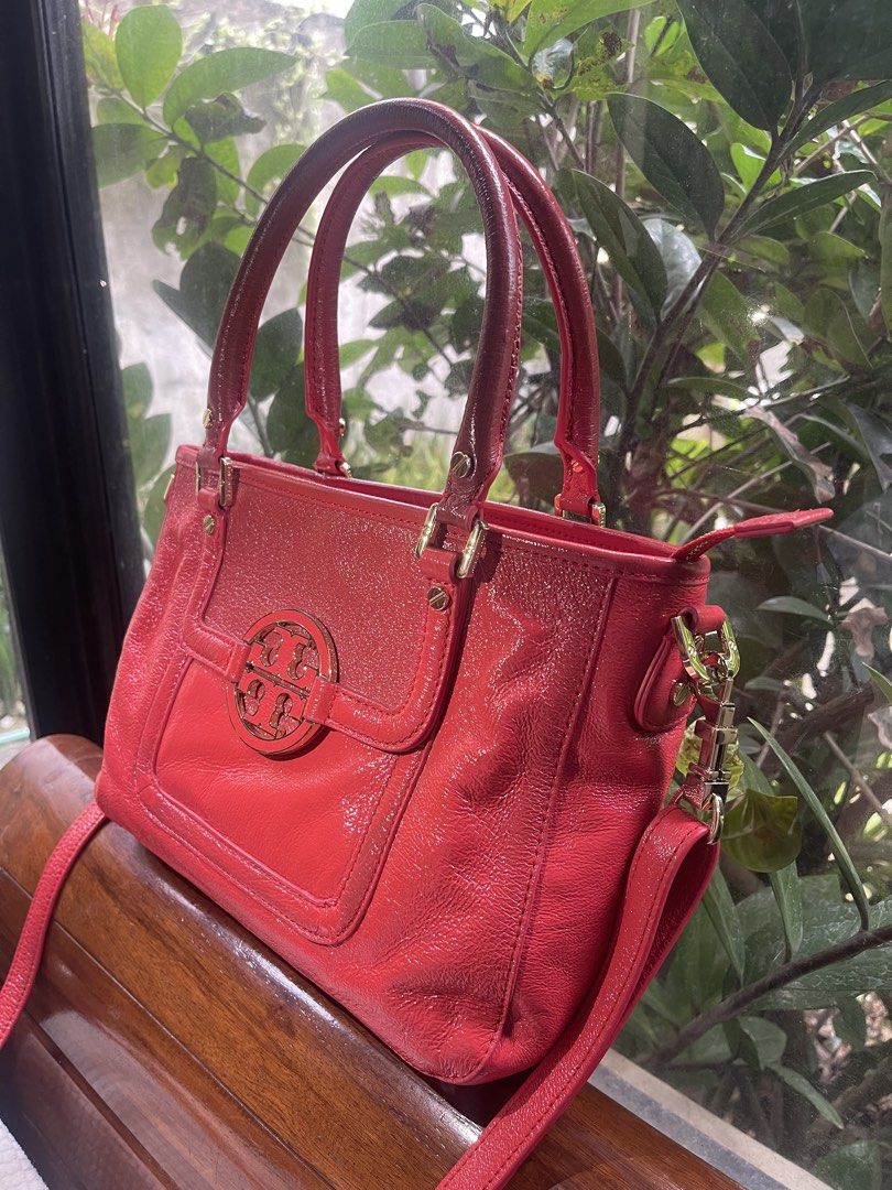 Tory Burch Amanda Red Leather Tote Bag Authentic (Category: Luxury Bags & Wallets) located in Santa Rosa. Submitted by denisequi (Listing ID 1459930569, Image 2). Description: - Genuine red cow leather with a sleek, shiny finish. - Iconic gold Tory Burch logo hardware. - Versatile carrying options: comfortable top handles and a detachable shoulder strap. - Secure zipper closure for the main compartment. - Ideal for both daily errands and evening 