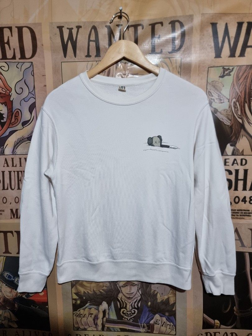 UNIQLO x KAWS Longsleeve Sweatshirt (Category: Longsleeves) located in Imus. Submitted by aim_for_less (Listing ID 1460067656, Image 2). Description: UNIQLO X KAWS LONGSLEEVE SWEATSHIRT - Size: (150) Kids on tag BUT can fit to women - DIMES: 19.5" X 24" - White long-sleeved sweatshirt - Features a small KAWS character graphic on the front left chest - Large KAWS character graphic on the back - Made from soft, comfortable material - Perfect for ca