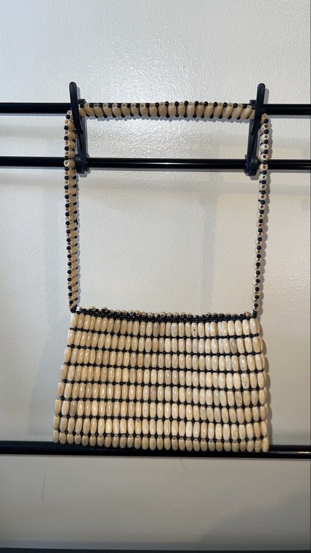 Unique Beaded Envelope Bag with Handle (Category: Clutches) located in Mandaluyong City. Submitted by chelseayb47224 (Listing ID 1459982891, Image 2). Description: - Unique envelope-style bag - Never used - Covered in wooden beads with black accents - Features a beaded handle - Ideal as a statement piece - Perfect for carrying essentials - Approximate dimensions: 8 inches wide x 6 inches tall.