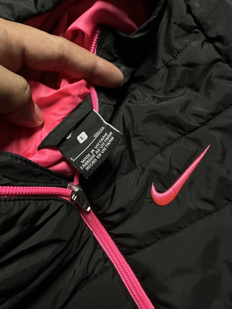 V4 - 4 Nike youth puffer jacket (Category: Hoodies) located in Bauang. Submitted by laceituplu (Listing ID 1460082687, Image 3). Description: Nike youth puffer jacket featuring a bright pink hood lining, zipper, and matching pink Swoosh logo on the chest..