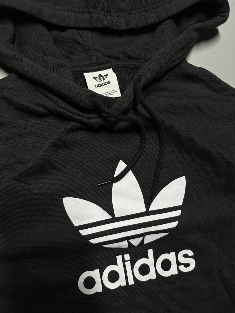 V4 - 6 Adidas Hoodie (Category: Hoodies) located in Bauang. Submitted by laceituplu (Listing ID 1460083732, Image 2). Description: black adidas Adicolor Classics Trefoil Hoodie featuring a large white Trefoil logo and text on the chest..