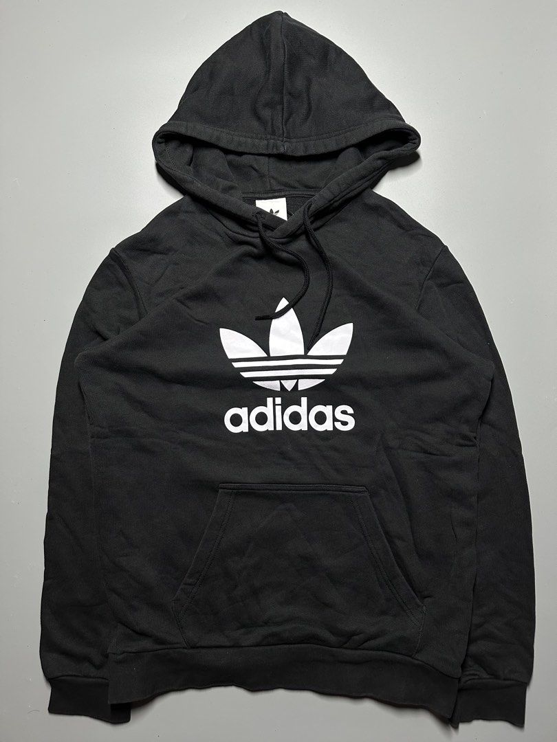 V4 - 6 Adidas Hoodie (Category: Hoodies) located in Bauang. Submitted by laceituplu (Listing ID 1460083732, Image 1). Description: black adidas Adicolor Classics Trefoil Hoodie featuring a large white Trefoil logo and text on the chest..