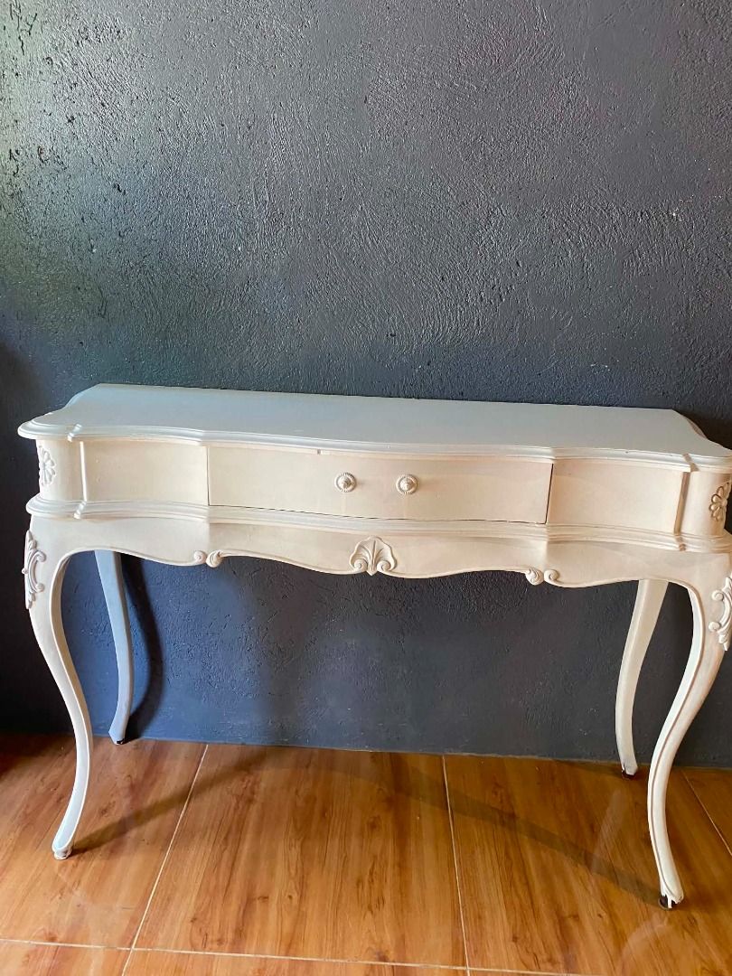 Vintage French Provincial Console Table with Drawer (Category: Tables & Sets) located in Minglanilla. Submitted by naquilagretchen (Listing ID 1460038514, Image 2). Description: - Beautiful cream-colored console table - Features a single drawer with two small knobs - Ornate, curved legs with carved details on sides and front - Ideal for entryways or as a vanity - Approximate dimensions: [insert length] x [insert depth] x [insert height].