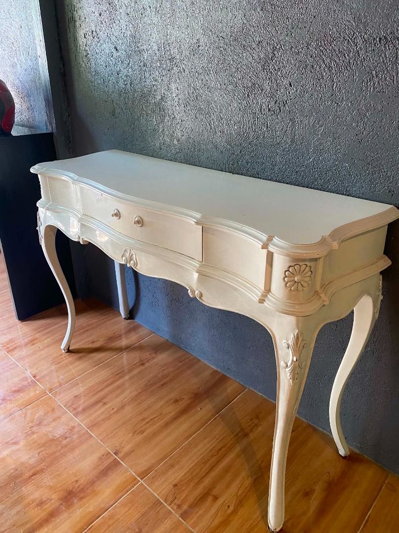 Vintage French Provincial Console Table with Drawer (Category: Tables & Sets) located in Minglanilla. Submitted by naquilagretchen (Listing ID 1460038514, Image 3). Description: - Beautiful cream-colored console table - Features a single drawer with two small knobs - Ornate, curved legs with carved details on sides and front - Ideal for entryways or as a vanity - Approximate dimensions: [insert length] x [insert depth] x [insert height].
