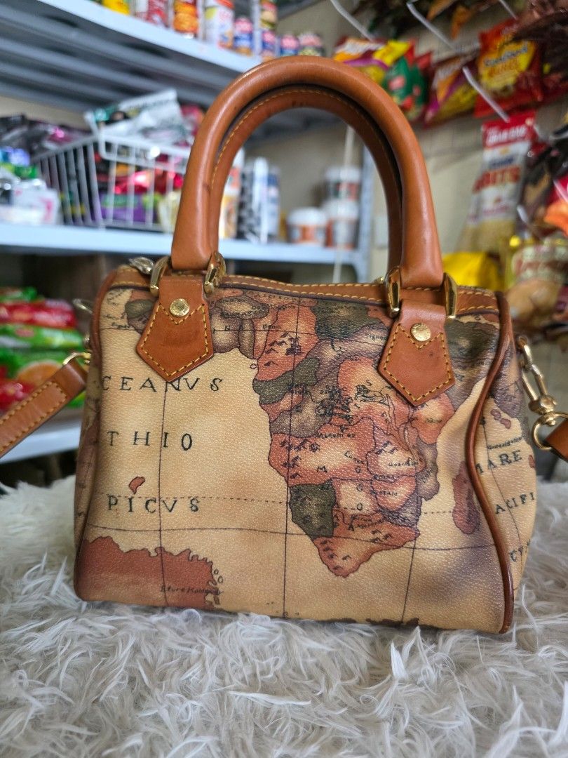 Vintage Map Print Bag (Category: Cross-body Bags) located in Lemery. Submitted by venus23 (Listing ID 1459932688, Image 3). Description: - Adorable satchel bag with a vintage world map print. - Features stylish tan leather trim and handles. - Accented with elegant gold hardware. - Comes with a detachable shoulder strap for versatile carrying. - Compact size: approximately 8 inches wide and 6 inches tall. - Ideal for travel adventures or chic ever