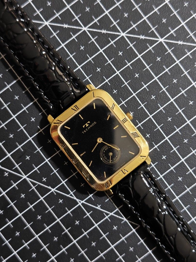 Vintage Technos Gold Tone Rectangular Black Dial Watch (Category: Luxury Watches) located in Makati City. Submitted by reyf86 (Listing ID 1459915779, Image 1). Description: - Elegant gold-tone rectangular watch - Classic black dial with Roman numerals - Convenient seconds sub-dial - Stylish glossy black leather strap - Durable stainless steel back - Water-resistant for everyday wear - Authentic Swiss made quality - A timeless addition to any coll