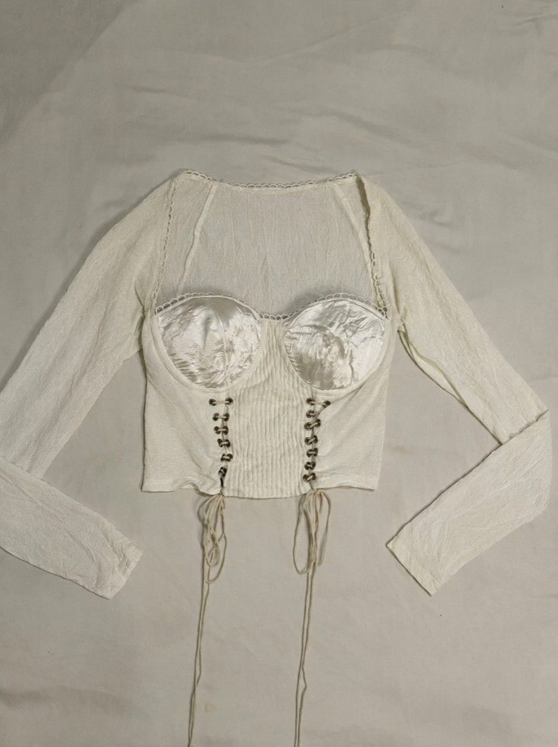 White Corset Top with Sheer Long Sleeves (Category: Others Tops) located in Binan City. Submitted by declutterbyjwy (Listing ID 1459938471, Image 2). Description: - can fit xs-m - good as new, never used & no flaws - with satin bustier and lace trim - lace-up detailing down the front - cropped length.