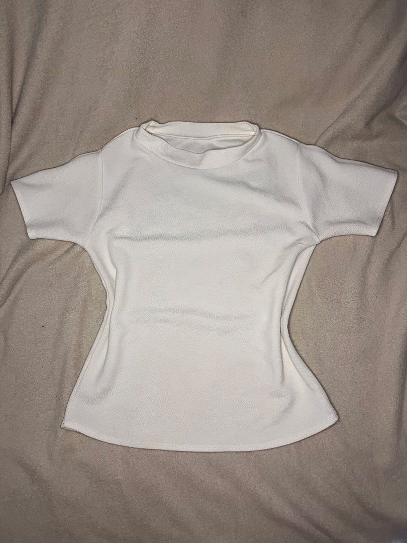 White Mock Neck Short Sleeve Top (Category: Blouses) located in Tanauan. Submitted by leighshin (Listing ID 1460036403, Image 1). Description: - White top - Mock neck with short sleeves - Textured fabric - Fitted waist with slight flare hem - Simple and versatile design - Perfect for layering or wearing alone.