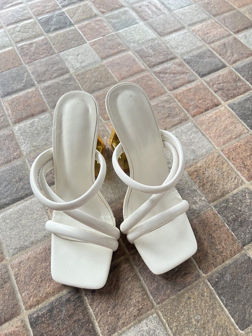 White Square Toe Heels with Gold Geometric Block Heels (Category: Heels) located in Manila. Submitted by saintnasti (Listing ID 1460088763, Image 1). Description: - White mule heels - Square toe - Unique gold geometric block heel - Strappy design across the foot - Protective plastic still attached to soles - Size: 37 - Ideal for elevating any outfit.
