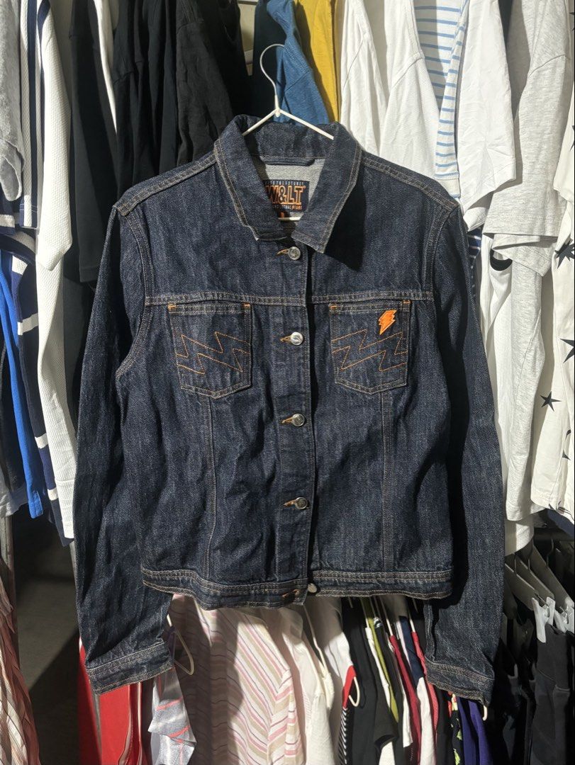 W&LT "Kiss The Future" Indigo Denim jacket (Category: Coats, Jackets and Outerwear) located in Manila. Submitted by why_notph (Listing ID 1460100653, Image 1). Description: - W&LT indigo denim jacket - Features 'Kiss The Future' slogan and lightning bolt graphic on chest pocket - Button-up front with metal buttons - Classic denim jacket style - Ideal for layering - Dimensions: Length - 22.5 Width - 19 Sleeve - 25.