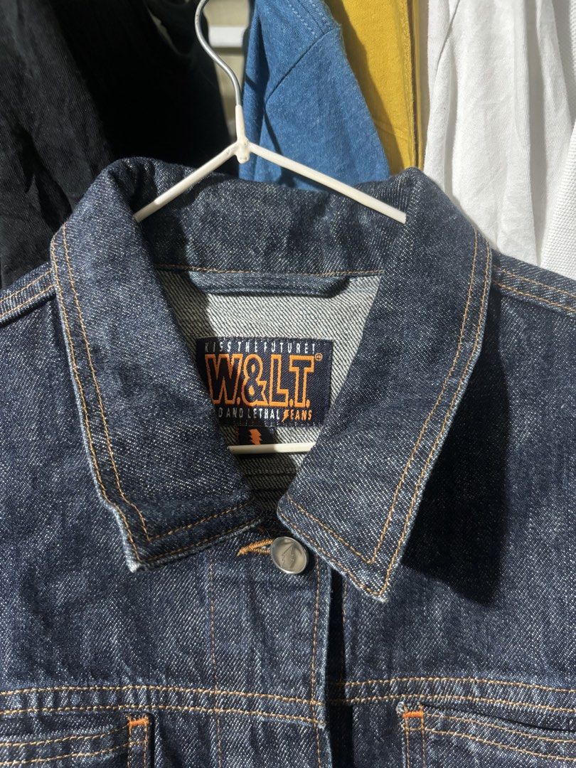 W&LT "Kiss The Future" Indigo Denim jacket (Category: Coats, Jackets and Outerwear) located in Manila. Submitted by why_notph (Listing ID 1460100653, Image 2). Description: - W&LT indigo denim jacket - Features 'Kiss The Future' slogan and lightning bolt graphic on chest pocket - Button-up front with metal buttons - Classic denim jacket style - Ideal for layering - Dimensions: Length - 22.5 Width - 19 Sleeve - 25.