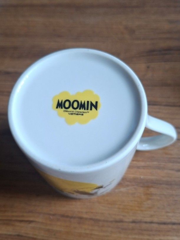 Yamaka Moomin Mug (Category: Coffee & Tea Tableware) located in Consolacion. Submitted by luxekerei (Listing ID 1457583114, Image 3). Description: - is a Yamaka Moomin ceramic mug featuring an illustration of Moomintroll and Snorkmaiden in a yellow cloud design. Brand: Yamaka (Japan) Design: Yellow and white with Moomin characters in the clouds Size: Approximately 8 cm in diameter and 9 cm to 9.5 cm in height.