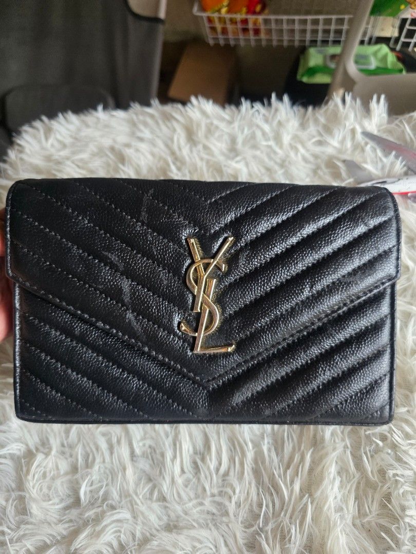 YSL Black Chevron Wallet (Category: Cross-body Bags) located in Lemery. Submitted by venus23 (Listing ID 1460025649, Image 1). Description: - black YSL wallet - Elegant chevron stitching - Signature gold YSL logo on front - Interior: Card slots and zipped compartment - Detachable chain strap included - Made from premium leather - Ideal for carrying essentials.