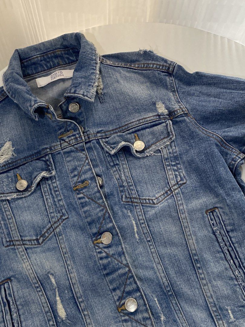 Z1975 Zara Basic Denim Jacket (Category: Coats, Jackets and Outerwear) located in Manila. Submitted by shoppwithrona (Listing ID 1460071120, Image 3). Description: - Classic blue denim jacket from Zara - Distressed and ripped details on shoulders and hem - Button-up front with chest pockets - Size: EUR M / USA 8 / MEX 28 - Made in Bangladesh.