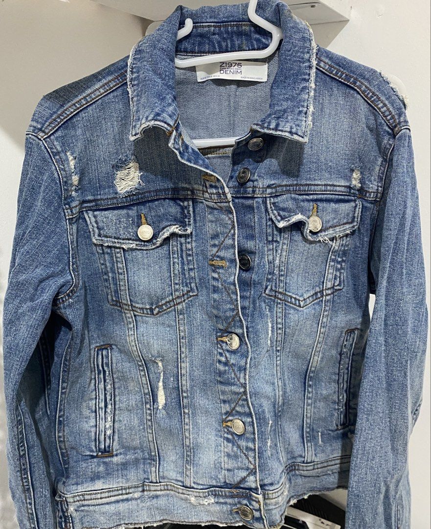 Z1975 Zara Basic Denim Jacket (Category: Coats, Jackets and Outerwear) located in Manila. Submitted by shoppwithrona (Listing ID 1460071120, Image 1). Description: - Classic blue denim jacket from Zara - Distressed and ripped details on shoulders and hem - Button-up front with chest pockets - Size: EUR M / USA 8 / MEX 28 - Made in Bangladesh.