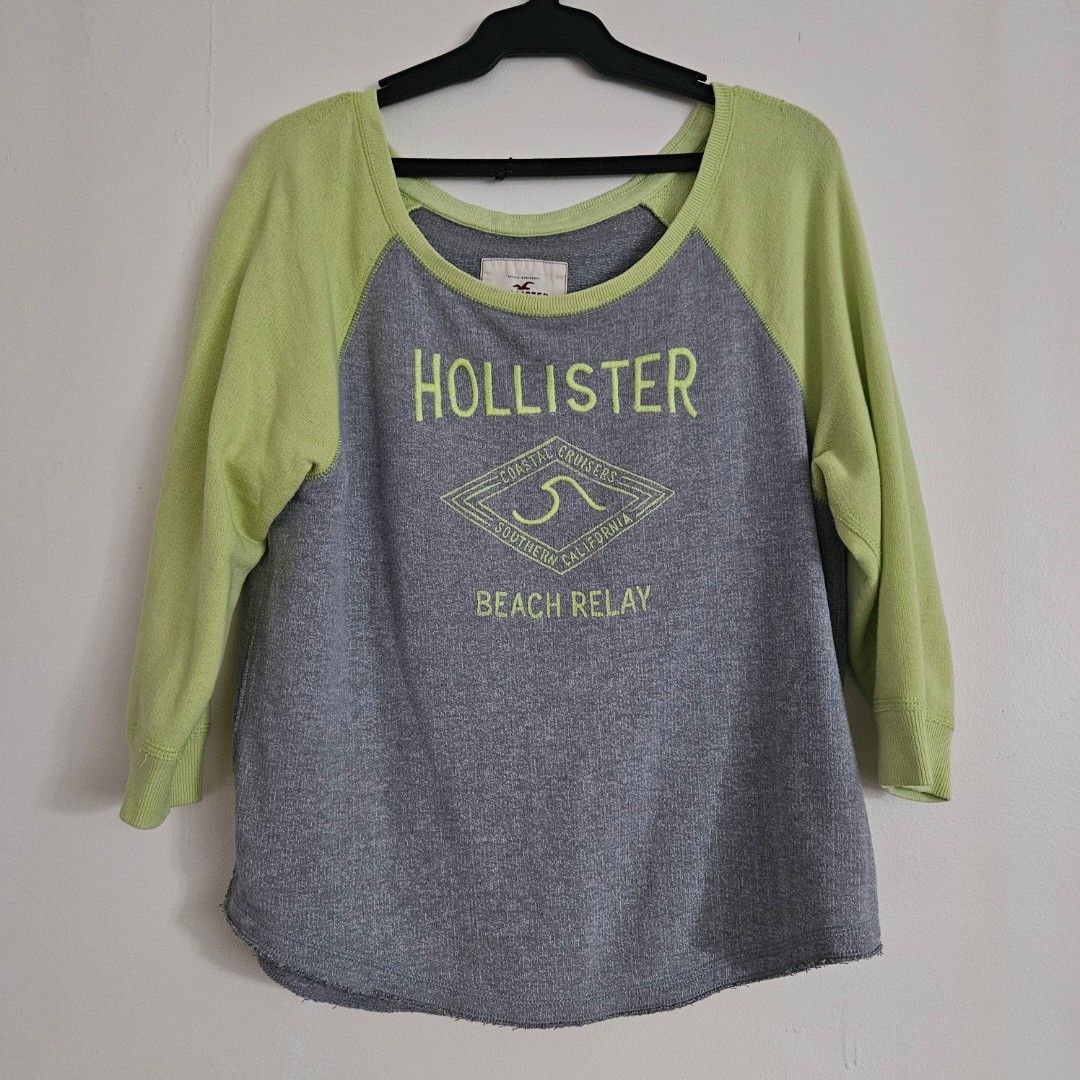 70. Hollister Grey & Lime Green Raglan Sweatshirt Medium (Category: Longsleeves) located in San Juan City. Submitted by titaofmanilaessentials (Listing ID 1460141973, Image 1). Description: - Hollister sweatshirt - Grey body with lime green raglan sleeves - 'Hollister Coastal California Beach Relay' graphic print on front - Raw hem detail.
